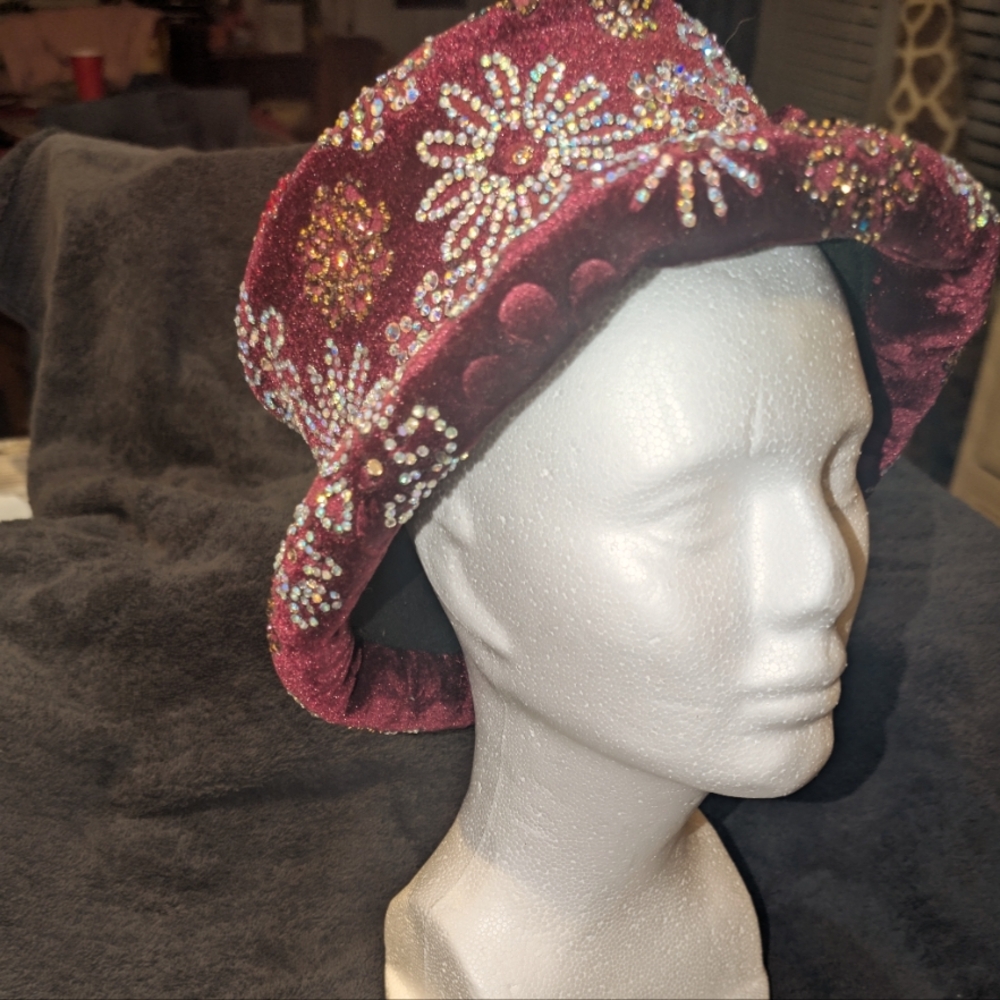 A burgundy velvet hat embellished with glass and Swavorsky crystal gems.